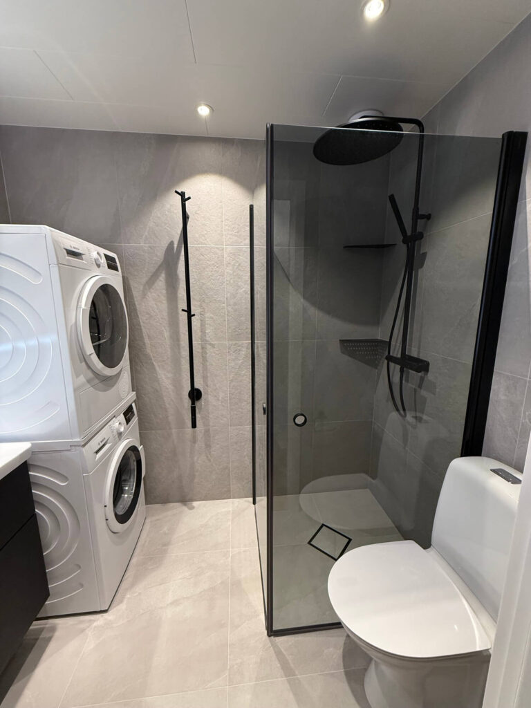 Modern badrumsrenovering med svarta detaljer